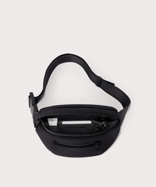 Dagne Dover Ace Fanny Pack in black unzipped, exposing the interior pockets