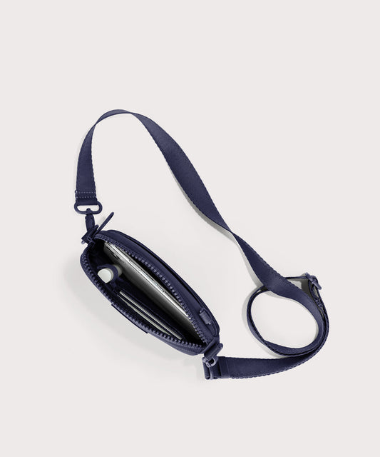 Dagne Dover Mara Phone Sling unzipped in dark blue seen from above, exposing the interior card slots.