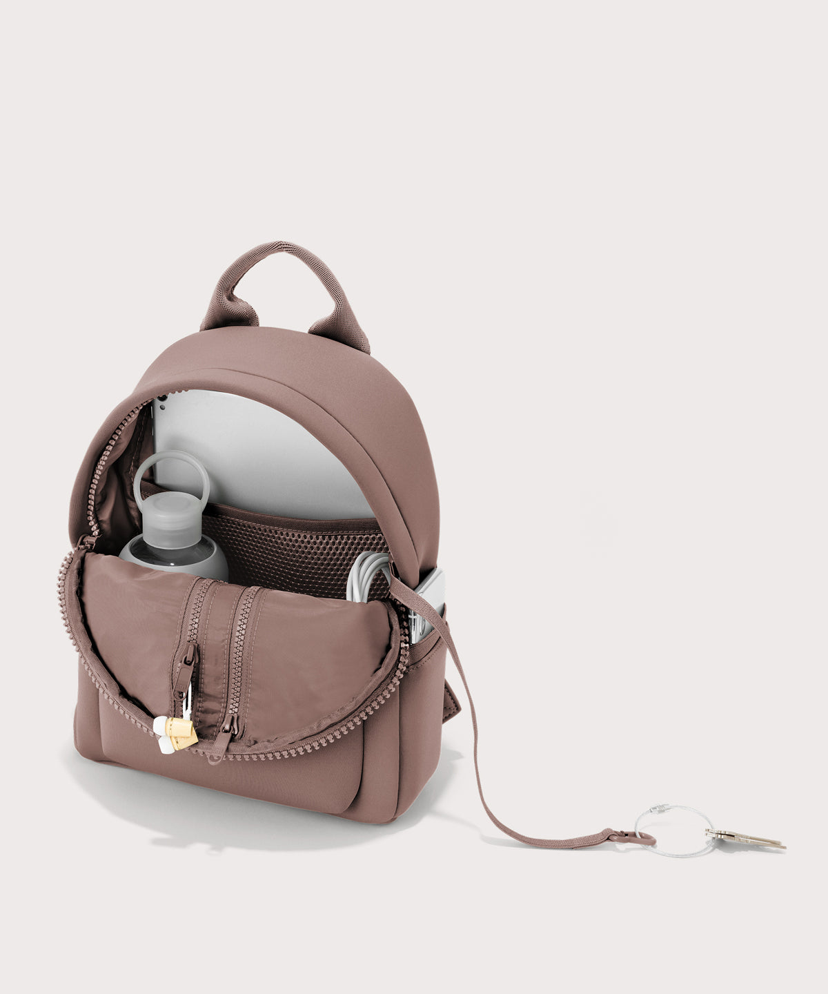 Dagne Dover Dakota Small Neoprene Backpack in pink unzipped, revealing the interior air mesh pockets.