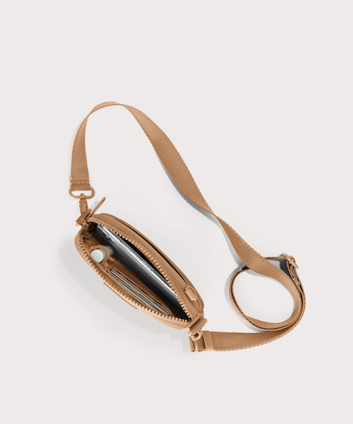 Dagne Dover Mara Phone Sling unzipped in brown camel seen from above, exposing the interior card slots.