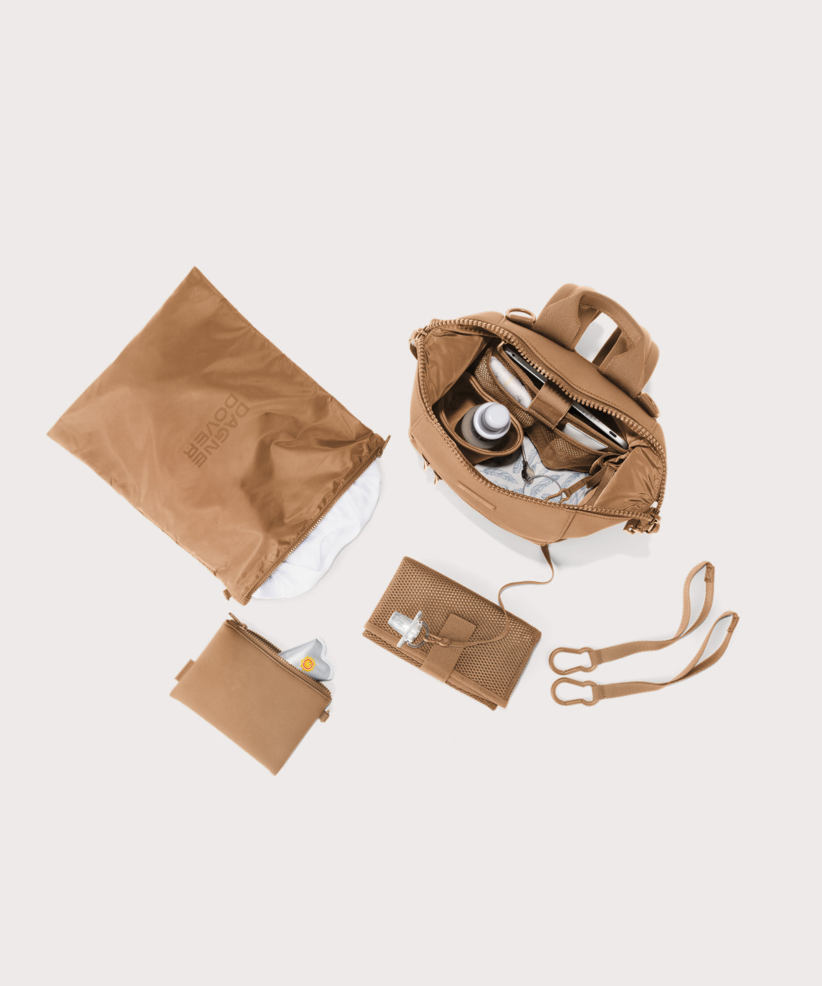 Dagne Dover small Indi Diaper Backpack in camel brown showing it's water resistant bag, interior pockets, and changing mat.