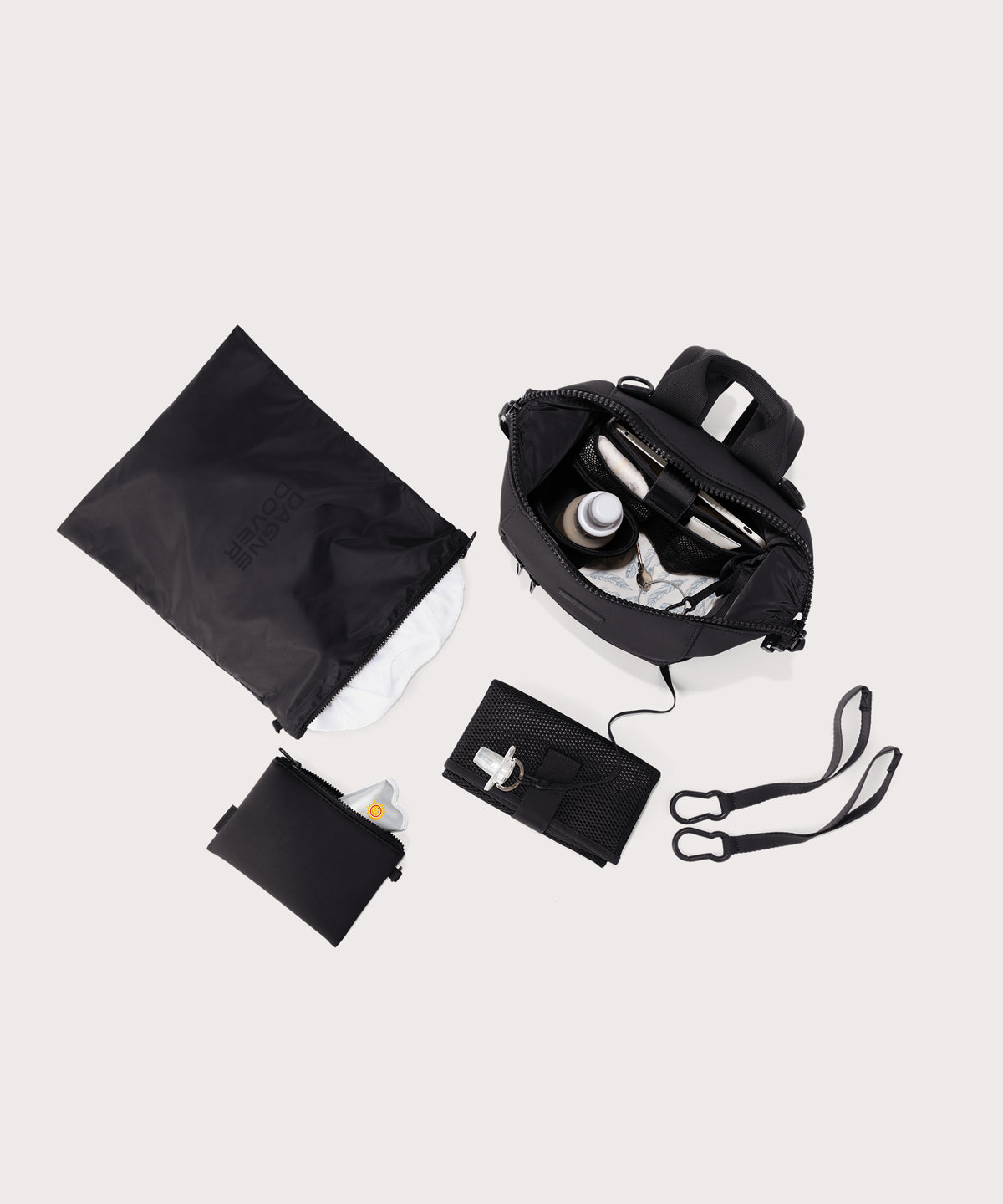 Dagne Dover small Indi Diaper Backpack in black showing it's water resistant bag, interior pockets, and changing mat.