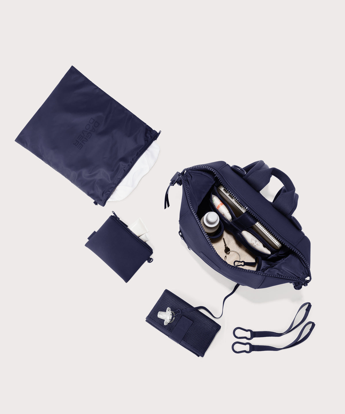 Dagne Dover medium Indi Diaper Backpack in dark blue showing it's water resistant bag, interior pockets, and changing mat.
