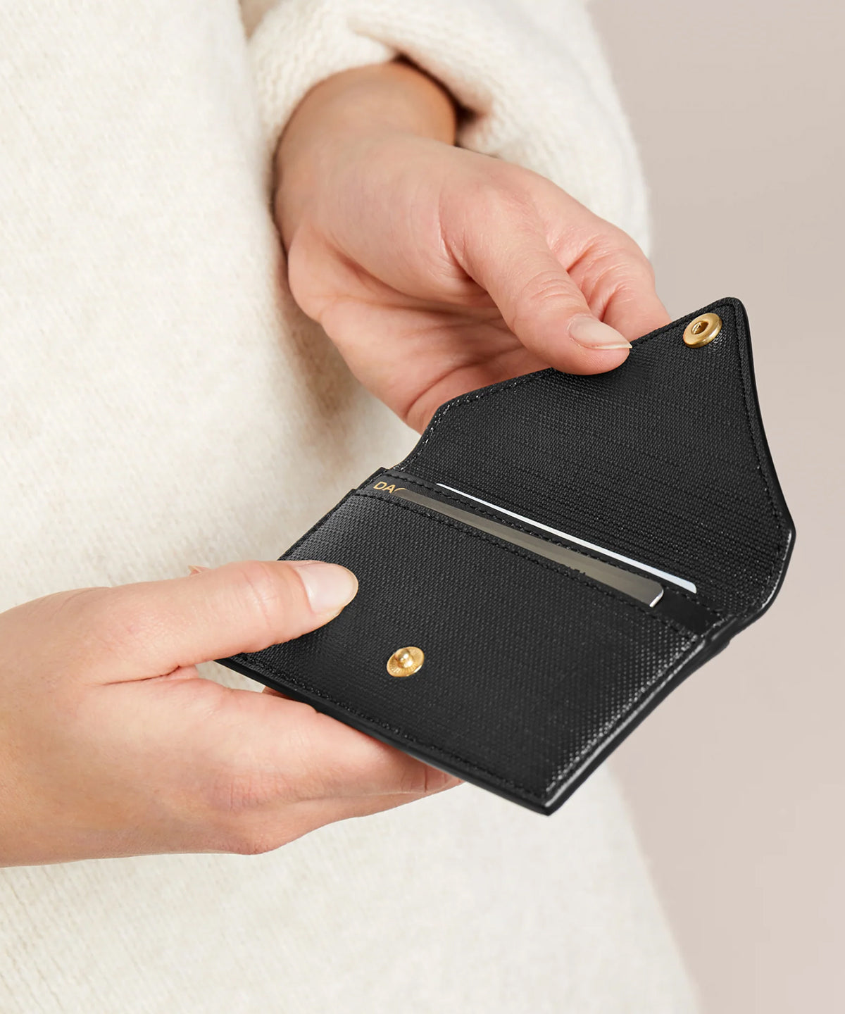 Someone opening the vegan Card Case in black.