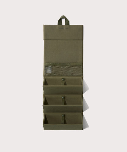 Dagne Dover Remi foldable glasses holder in dark green hung up.