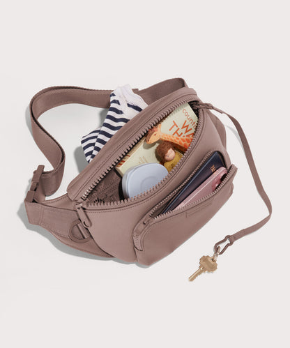Dagne Dover jax large Fanny Pack in pink unzipped, exposing the interior pockets.