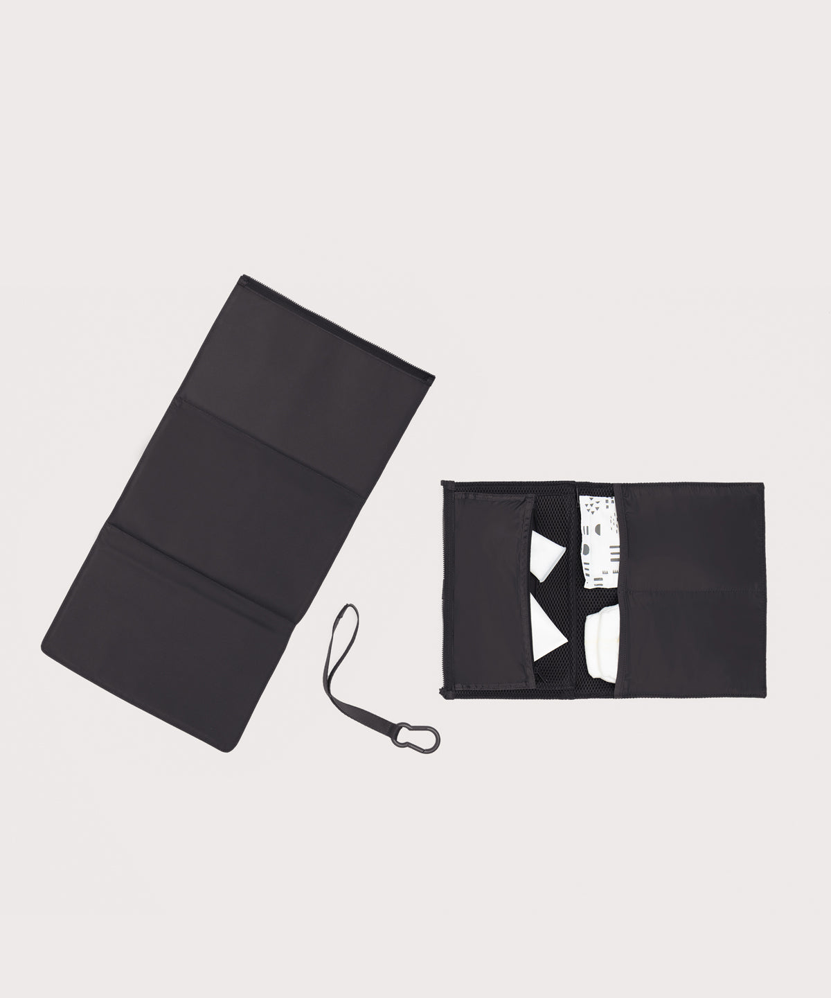 Dagne Dover Joey Changing Kit in black unfolded, revealing the interior zipper pocket and interior slip pockets.