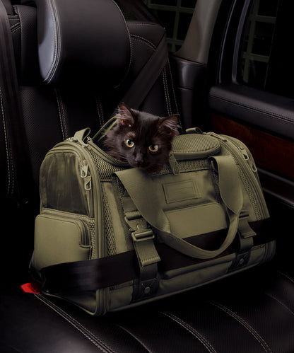 Dagne Dover small Kyoto Pet Carrier in a deep olive green displaying the two side release buckle clips to secure pet carrier to seat belt; a cat is inside the carrier. Caption: Ouija is a 7.8-lb American Longhair