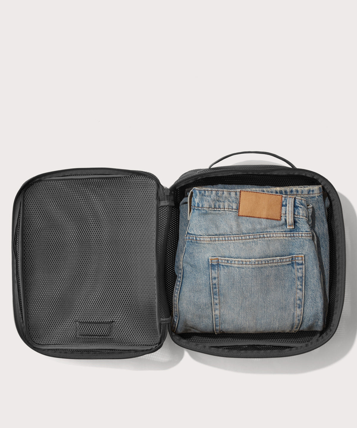 Large Roma packing cube in carbon black open with jeans inside